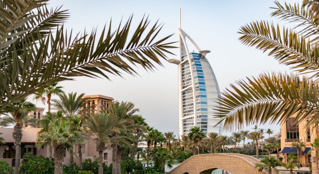 Scenic view of Burj Al Arab with surrounding palm trees and bridge in Dubai, UAE.
