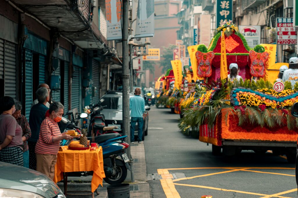 Colorful parade floats and people at a city street festival, showcasing vibrant cultural traditions.