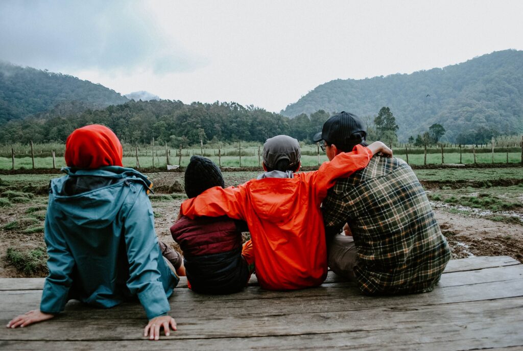 A family enjoying a peaceful moment together outdoors with scenic mountain views.