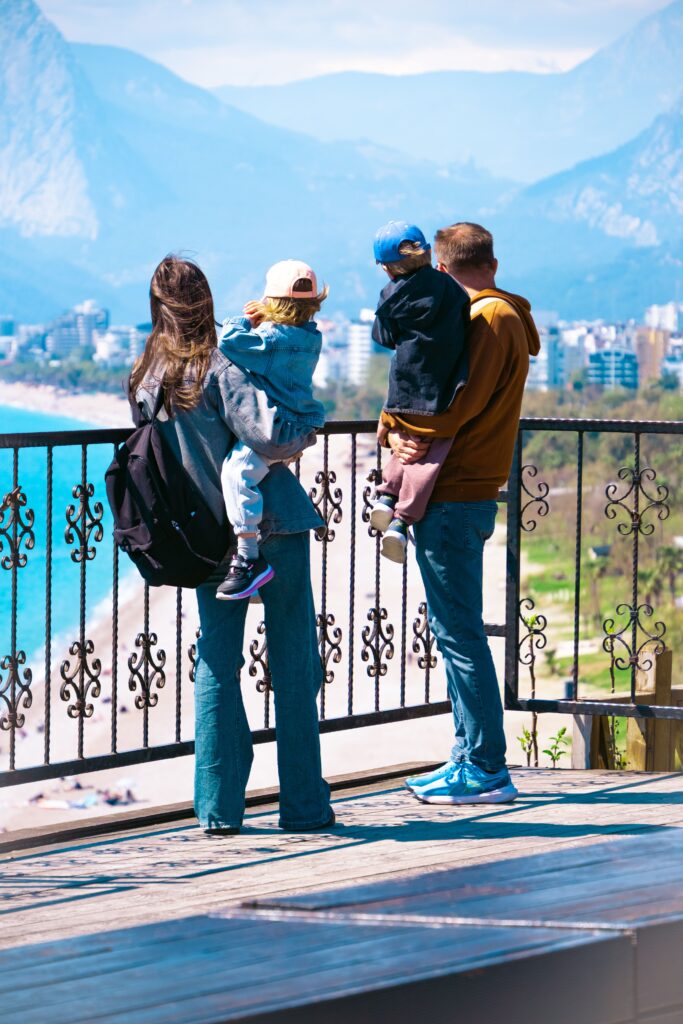 A family of four enjoying a scenic view of the beach and city skyline.