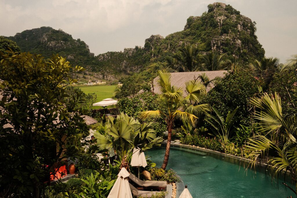 Relaxing tropical resort featuring a luxurious pool and stunning mountain views, perfect for travel enthusiasts.
