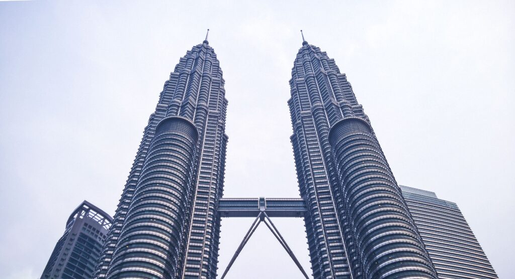 Iconic Petronas Twin Towers under a bright sky in Kuala Lumpur, Malaysia.